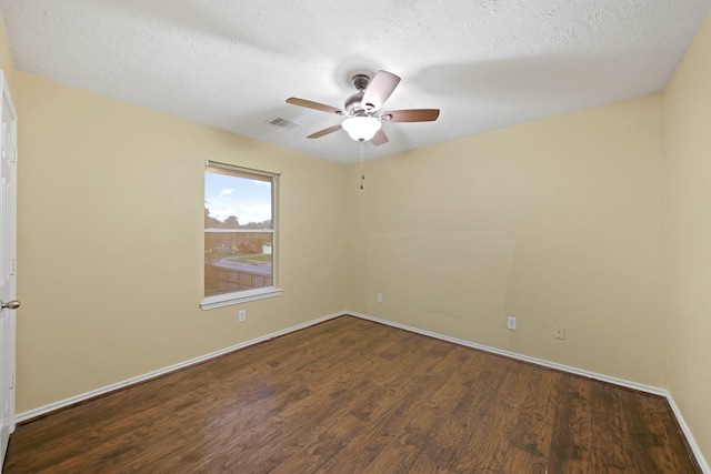 empty room featuring dark hardwood / wood-style flooring, a textured ceiling, and ceiling fan