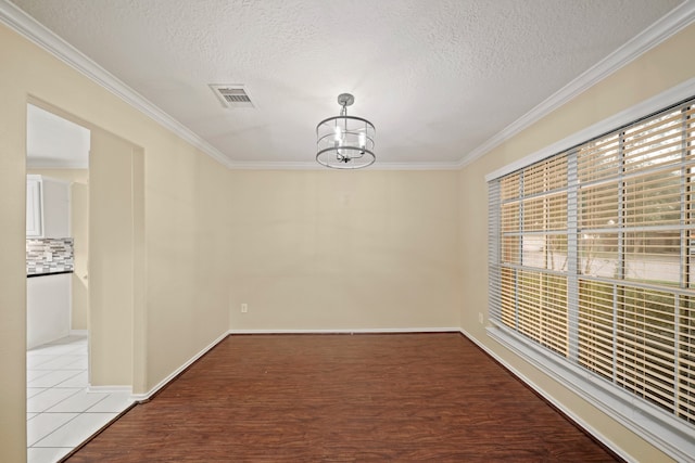 unfurnished dining area featuring crown molding, an inviting chandelier, light hardwood / wood-style floors, and a textured ceiling