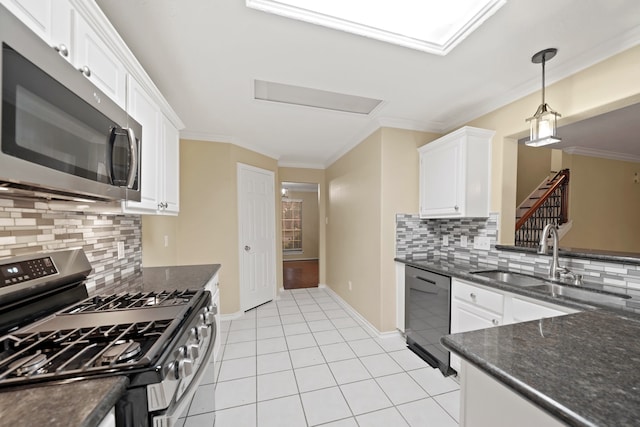 kitchen with stainless steel appliances, white cabinetry, sink, tasteful backsplash, and hanging light fixtures