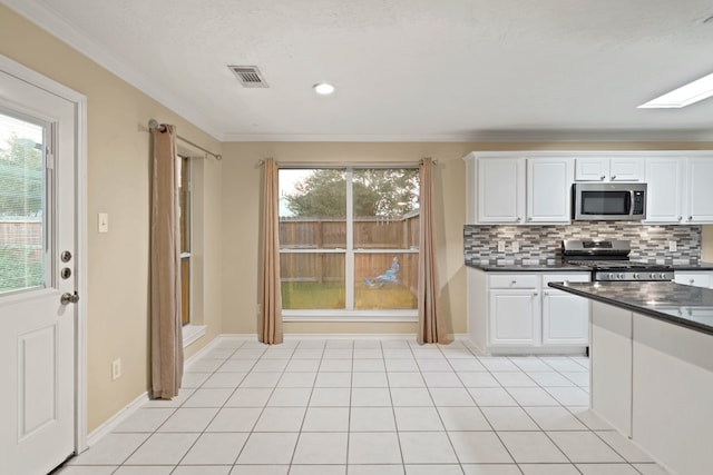 kitchen featuring white cabinetry, decorative backsplash, crown molding, and stainless steel appliances