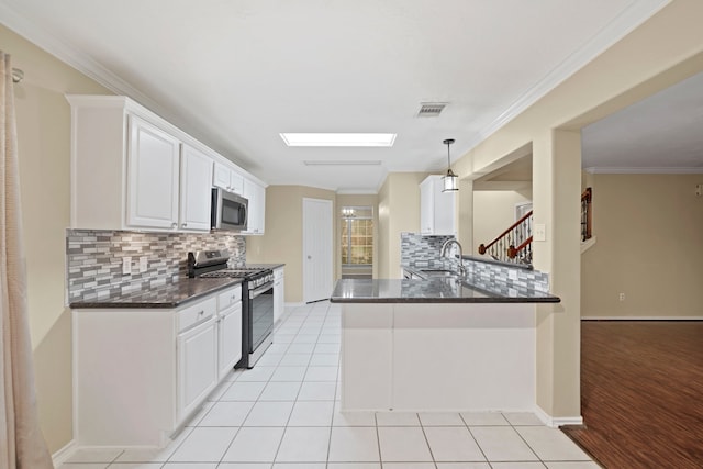 kitchen with crown molding, stainless steel appliances, white cabinetry, pendant lighting, and kitchen peninsula