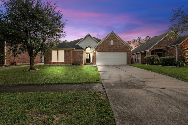 front of property with a garage and a yard