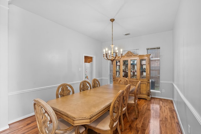 dining room with an inviting chandelier and wood-type flooring