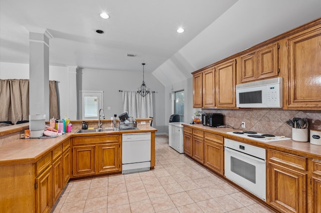 kitchen with sink, white appliances, a notable chandelier, pendant lighting, and vaulted ceiling