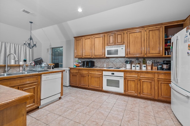 kitchen featuring white appliances, pendant lighting, sink, a chandelier, and lofted ceiling