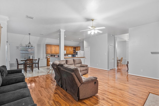 living room with ceiling fan with notable chandelier, light wood-type flooring, and decorative columns