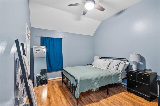 bedroom with light hardwood / wood-style floors, ceiling fan, and vaulted ceiling