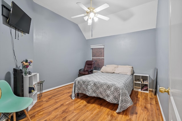 bedroom with hardwood / wood-style floors, vaulted ceiling, and ceiling fan