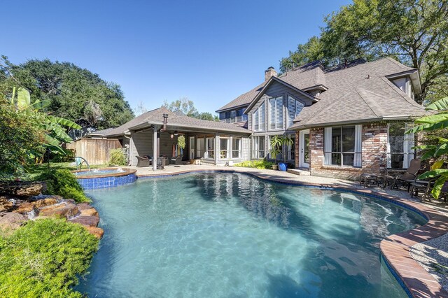 view of pool with a patio area and an in ground hot tub