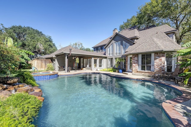 view of swimming pool featuring a patio, a pool with connected hot tub, a ceiling fan, and fence