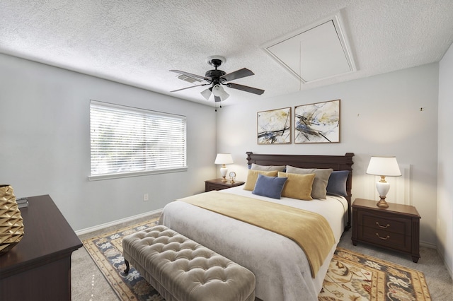 bedroom featuring ceiling fan, light carpet, and a textured ceiling