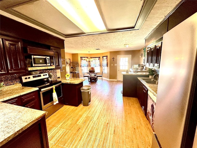 kitchen featuring decorative light fixtures, stainless steel appliances, and light stone counters