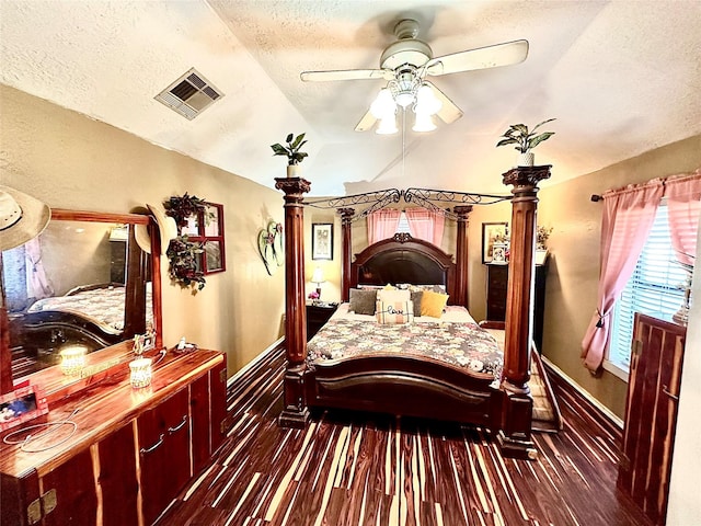 bedroom with a textured ceiling, ceiling fan, dark hardwood / wood-style flooring, and vaulted ceiling