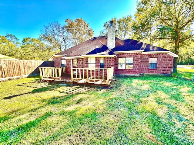 rear view of house with a yard and a wooden deck