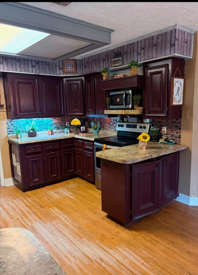 kitchen featuring light stone countertops, stainless steel appliances, and light wood-type flooring