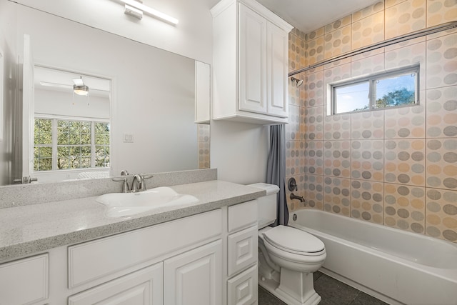 full bathroom with vanity, toilet, tiled shower / bath, and a wealth of natural light