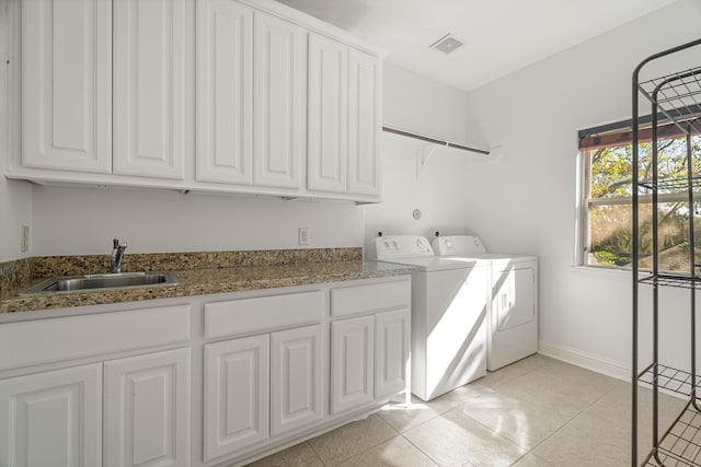 washroom with light tile patterned flooring, cabinets, independent washer and dryer, and sink