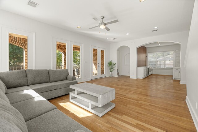 living room with ceiling fan and light hardwood / wood-style flooring