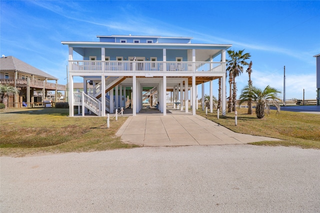 beach home with a front lawn, a carport, and a porch