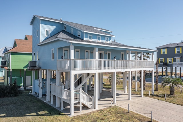 rear view of house with cooling unit, a carport, and a porch