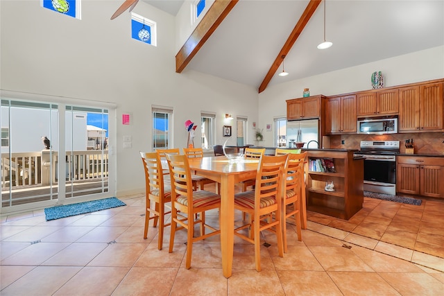 tiled dining room with beamed ceiling and high vaulted ceiling