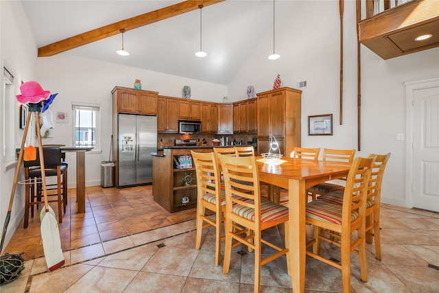 dining room featuring beam ceiling, light tile patterned floors, and high vaulted ceiling