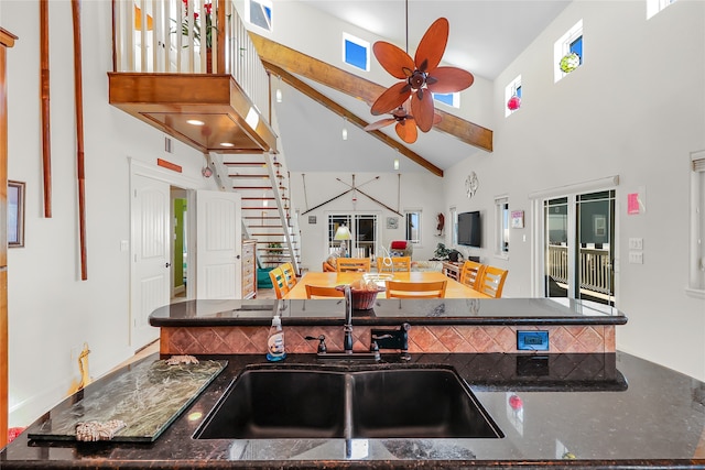 kitchen featuring a healthy amount of sunlight, high vaulted ceiling, sink, and ceiling fan