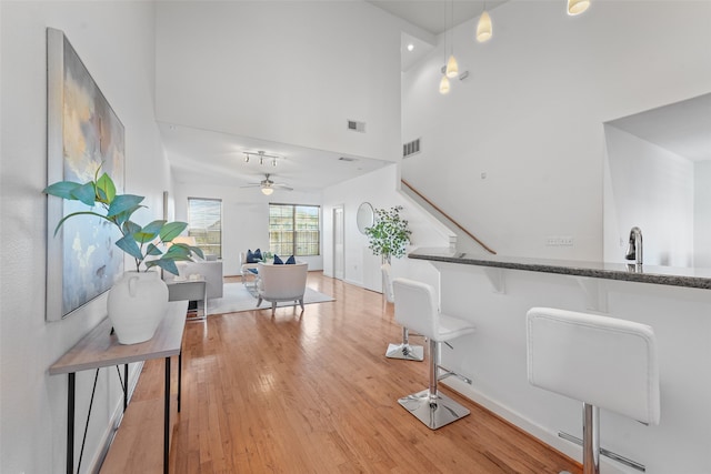 interior space with light wood-type flooring and high vaulted ceiling