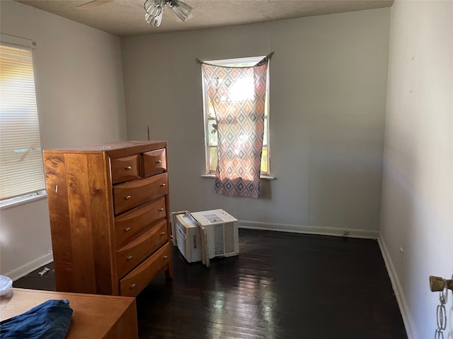 bedroom featuring ceiling fan, multiple windows, a textured ceiling, and dark hardwood / wood-style flooring