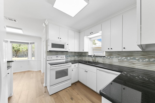 kitchen featuring white appliances, tasteful backsplash, white cabinetry, and sink