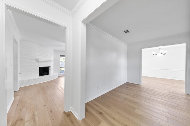 hall featuring a chandelier, light hardwood / wood-style floors, and ornamental molding