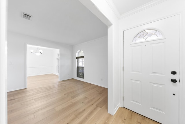 entrance foyer with light hardwood / wood-style flooring, ornamental molding, and a notable chandelier