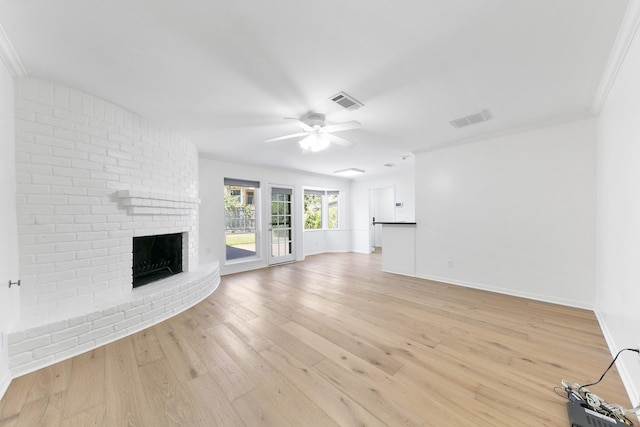 unfurnished living room with ceiling fan, crown molding, light hardwood / wood-style floors, and a brick fireplace