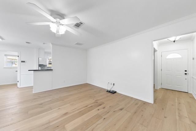 unfurnished living room featuring light hardwood / wood-style flooring, ceiling fan, and crown molding