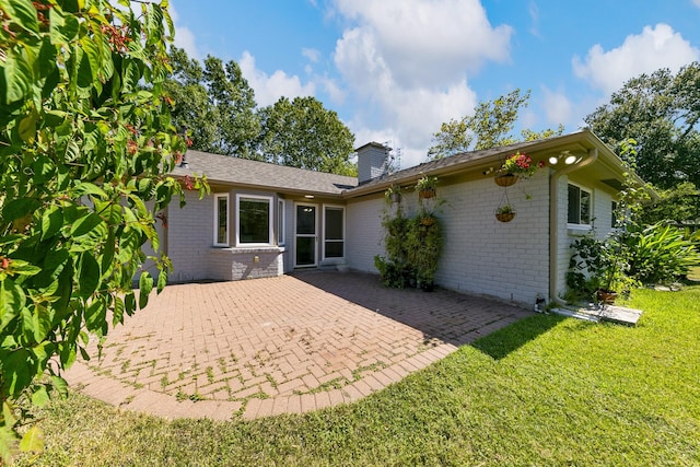 rear view of property with a yard and a patio