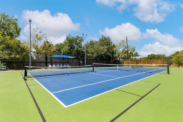 view of tennis court featuring basketball hoop