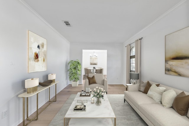 living room with crown molding, light hardwood / wood-style floors, and a notable chandelier