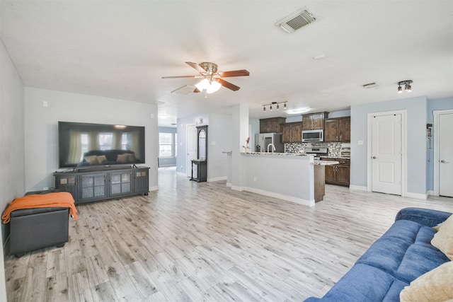 living room featuring ceiling fan and light hardwood / wood-style floors