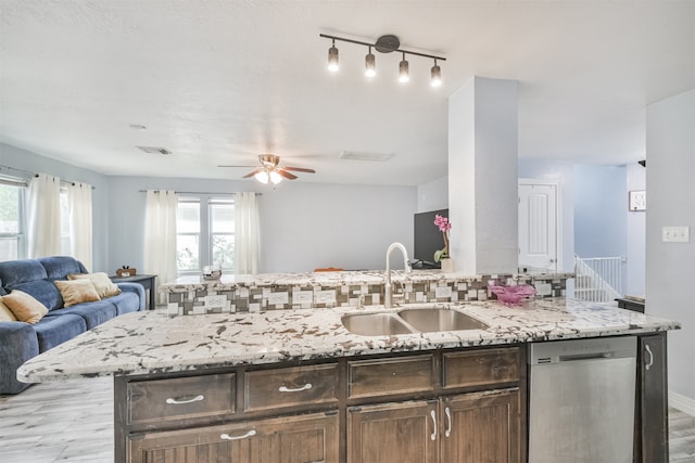 kitchen featuring a wealth of natural light, dark brown cabinets, sink, and dishwasher