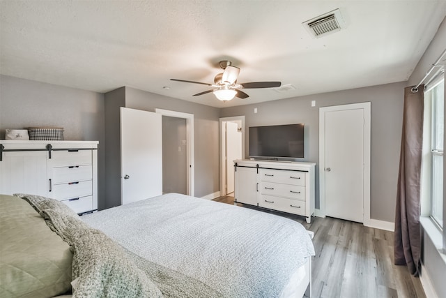 bedroom featuring a textured ceiling, light hardwood / wood-style flooring, and ceiling fan