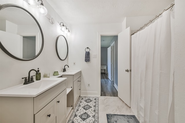 bathroom with vanity, a textured ceiling, and wood-type flooring