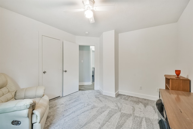 living area with light colored carpet and ceiling fan