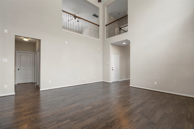 empty room featuring a high ceiling and dark wood-type flooring