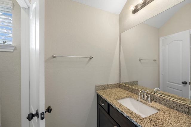 bathroom with vanity and vaulted ceiling