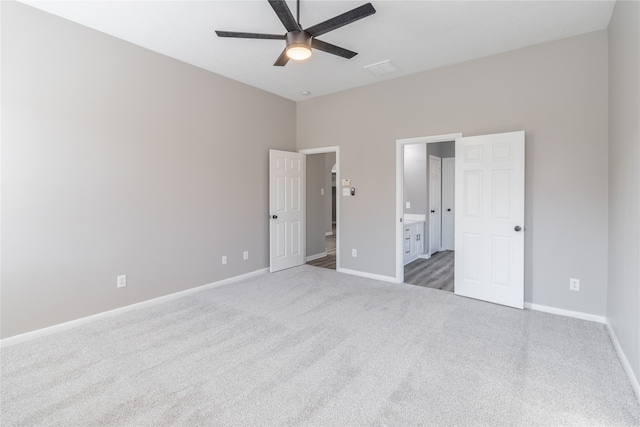 unfurnished bedroom with carpet, ceiling fan, and ensuite bath