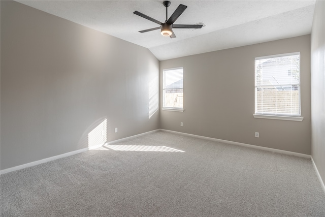 spare room featuring a textured ceiling, light carpet, ceiling fan, and vaulted ceiling