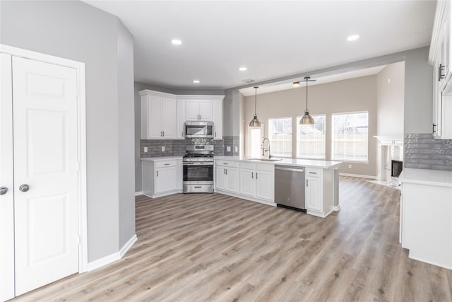 kitchen featuring white cabinets, light hardwood / wood-style floors, sink, and stainless steel appliances