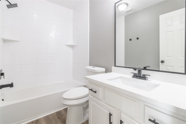 full bathroom with vanity, toilet, wood-type flooring, and tiled shower / bath