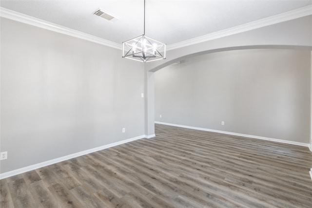 spare room with dark hardwood / wood-style floors, ornamental molding, and an inviting chandelier