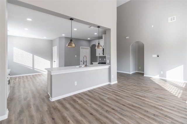 kitchen featuring hardwood / wood-style flooring, sink, kitchen peninsula, and hanging light fixtures